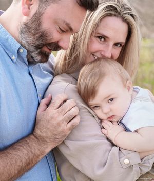 Tender family moment captured in soft natural lighting outdoors.