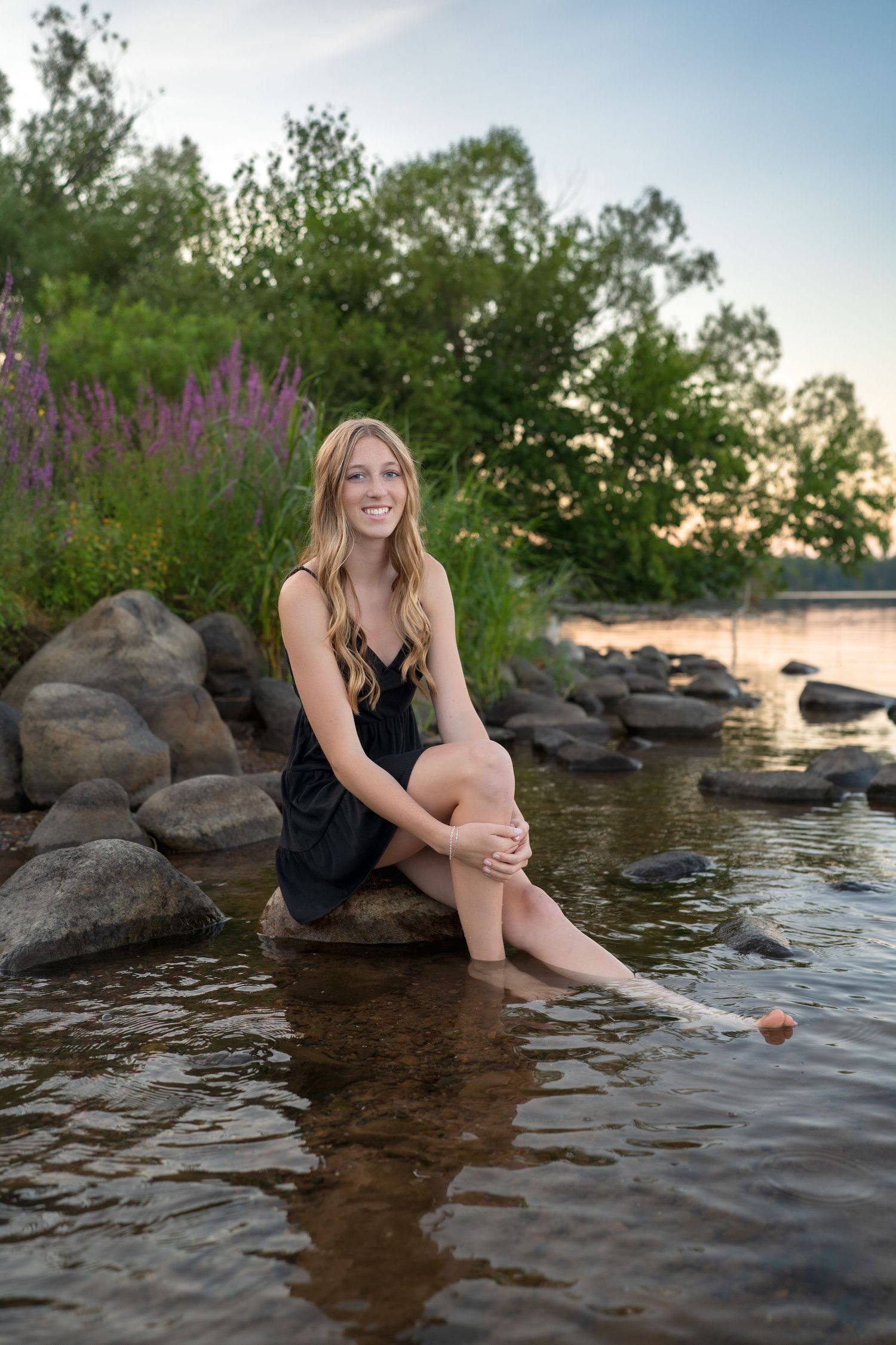A collection of sunset photos by a rocky lakeshore with purple wildflowers in the background.