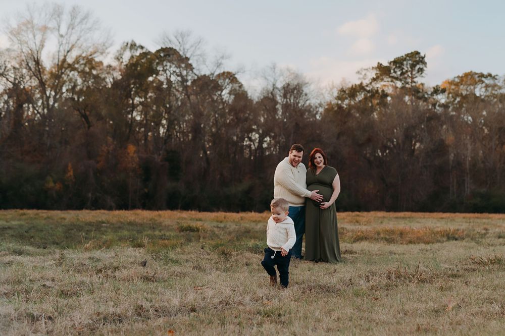 A couple shares tender moments in a golden field at sunset during their outdoor photo session.