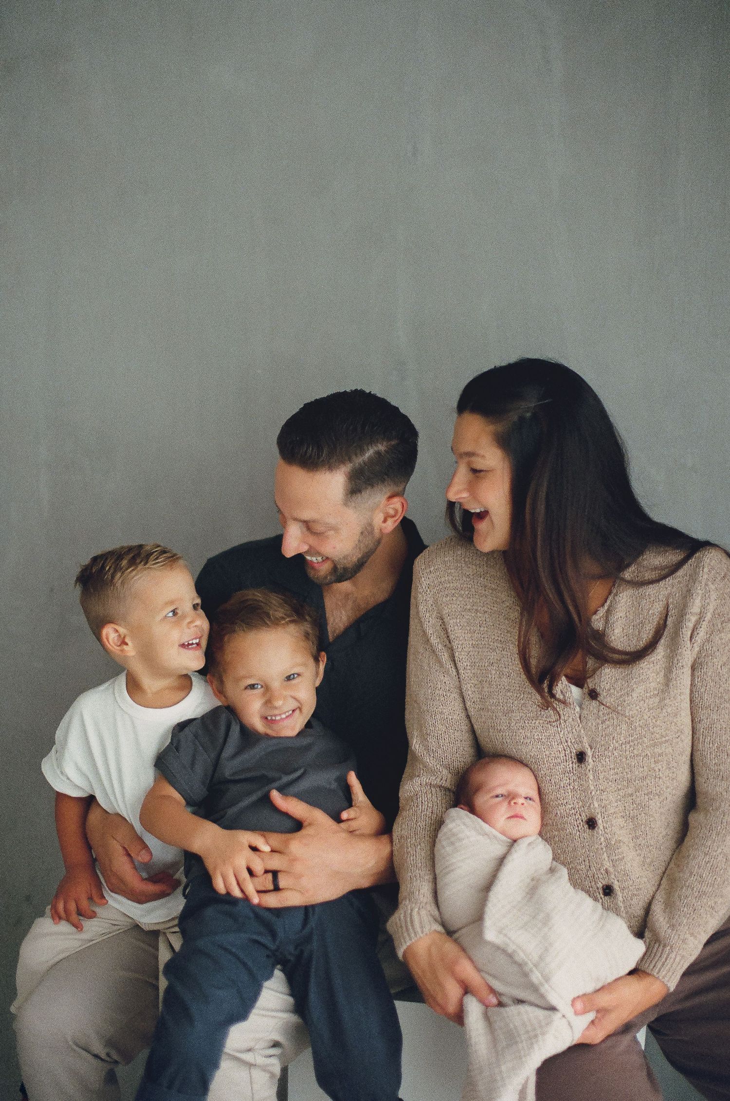 Studio family portraits in Orange County with mom cradling newborn