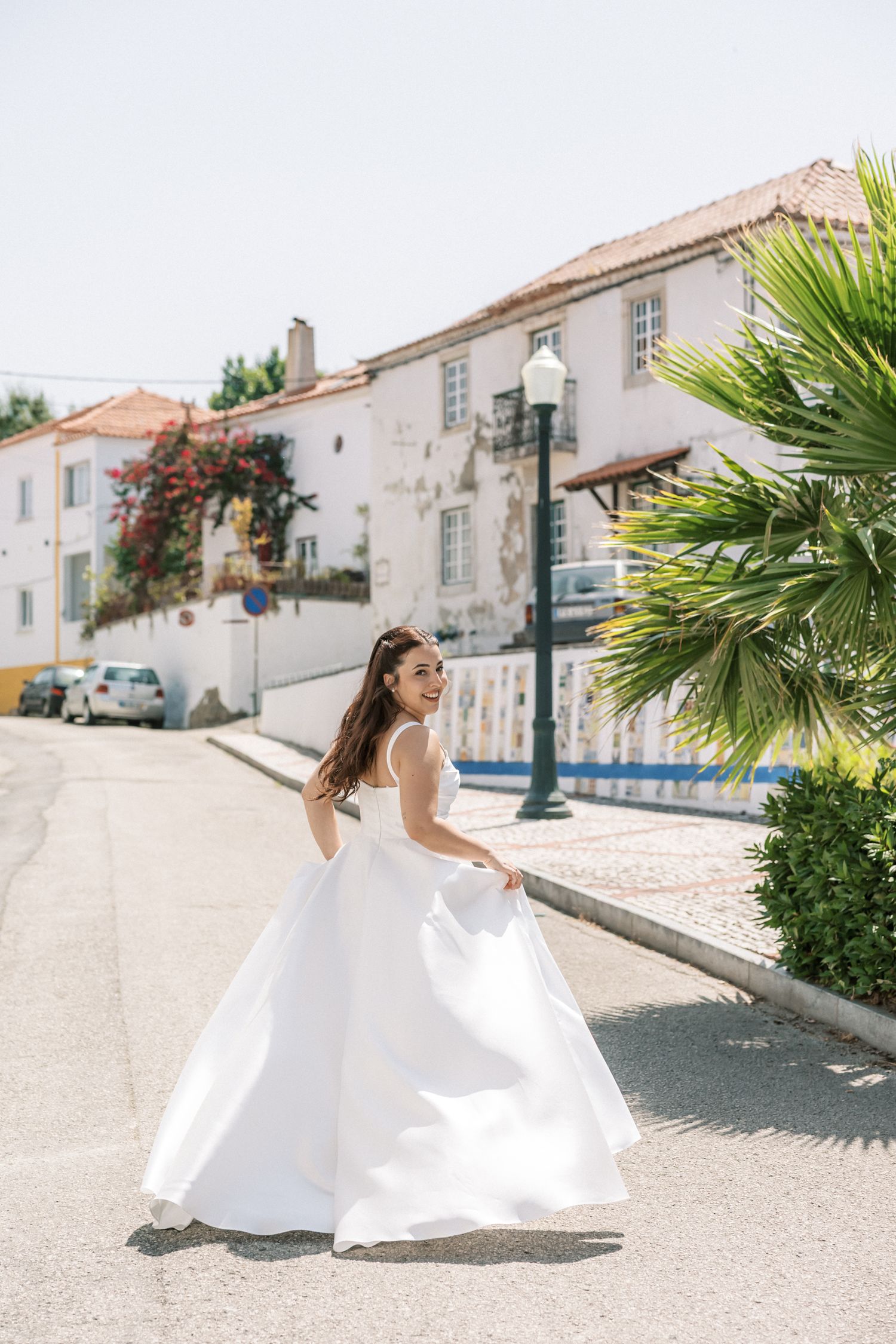 Bride walking through charming Portuguese village street in Portugal