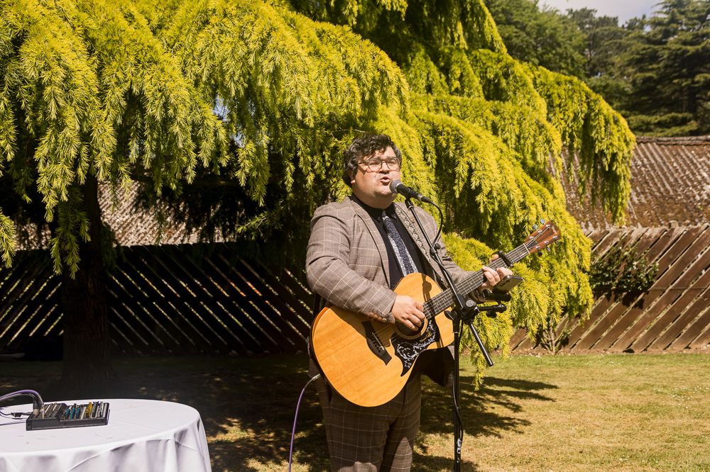 Beautiful yellow weeping willow trees frame an outdoor wedding venue.