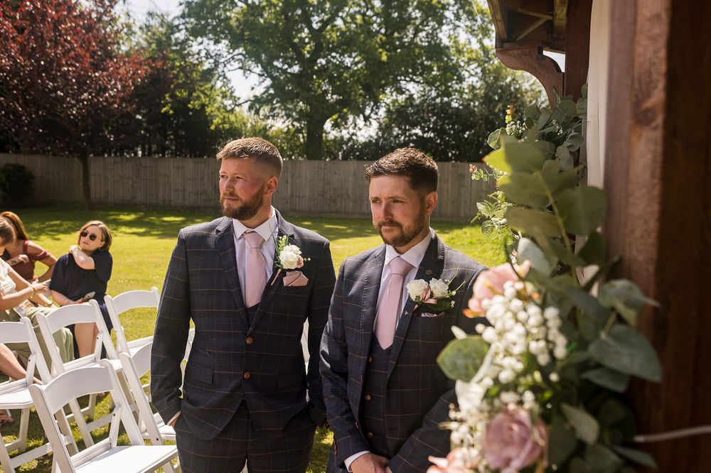 A wedding ceremony setup with floral decorations under a wooden gazebo.