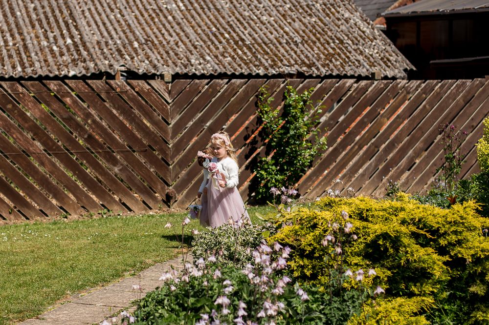 Garden wedding venue with wooden fence backdrop and floral decorations.