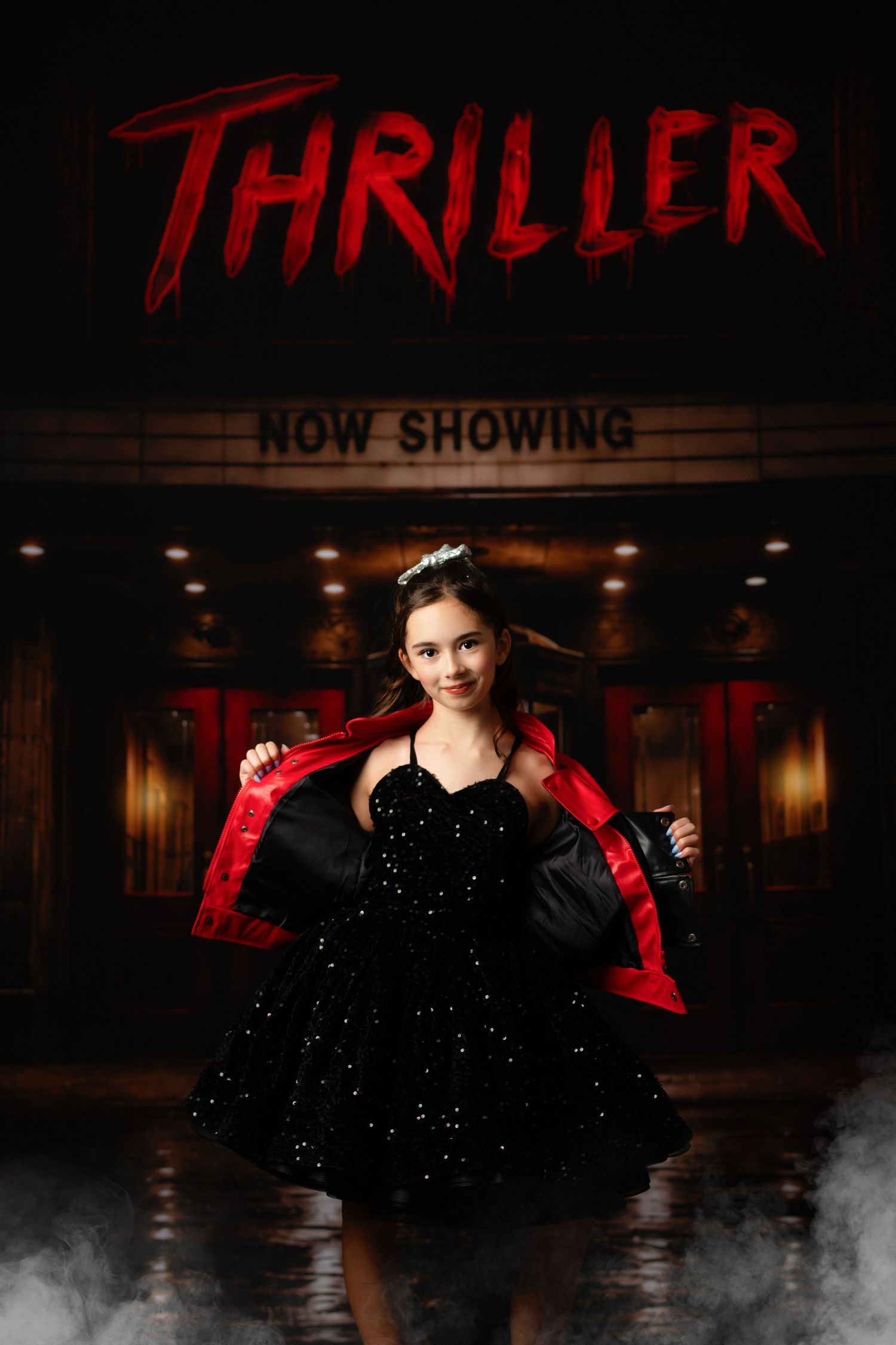 Young girl in black sparkly dress poses before a Thriller movie theater marquee with dramatic fog effects.