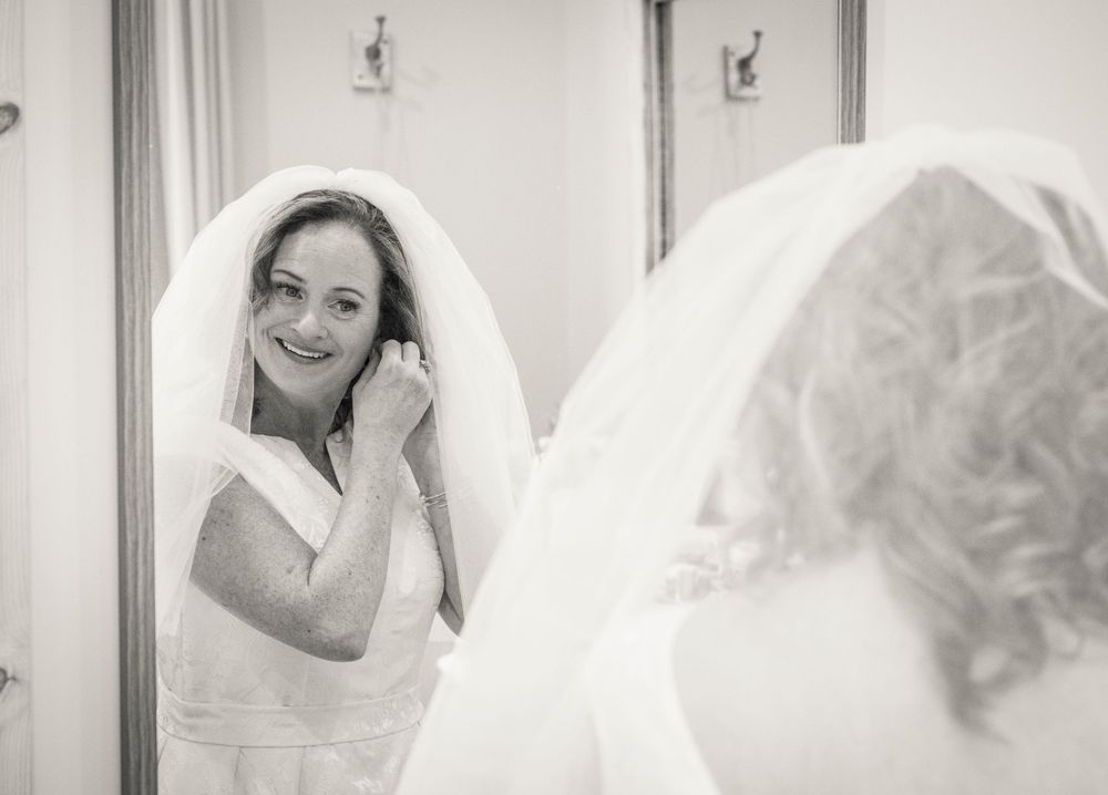 Black and white wedding photos showing joyful preparation moments in a bridal suite.