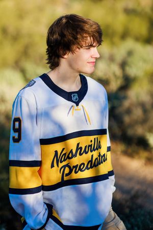 A series of photos showing someone wearing a retro-style white and yellow baseball jersey with navy blue trim.