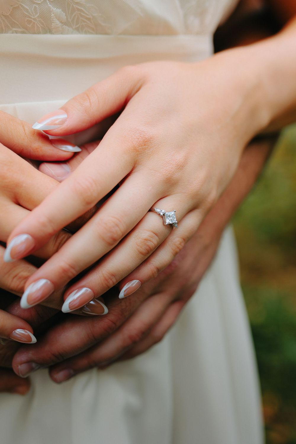 Close-up shots of hands wearing an elegant engagement ring with a white gold band and solitaire diamond.