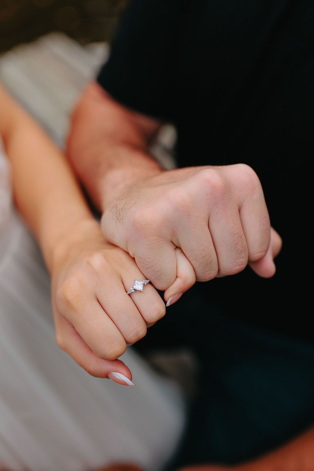 Close-up sequence of hands showing an engagement ring on a finger against a dark background.