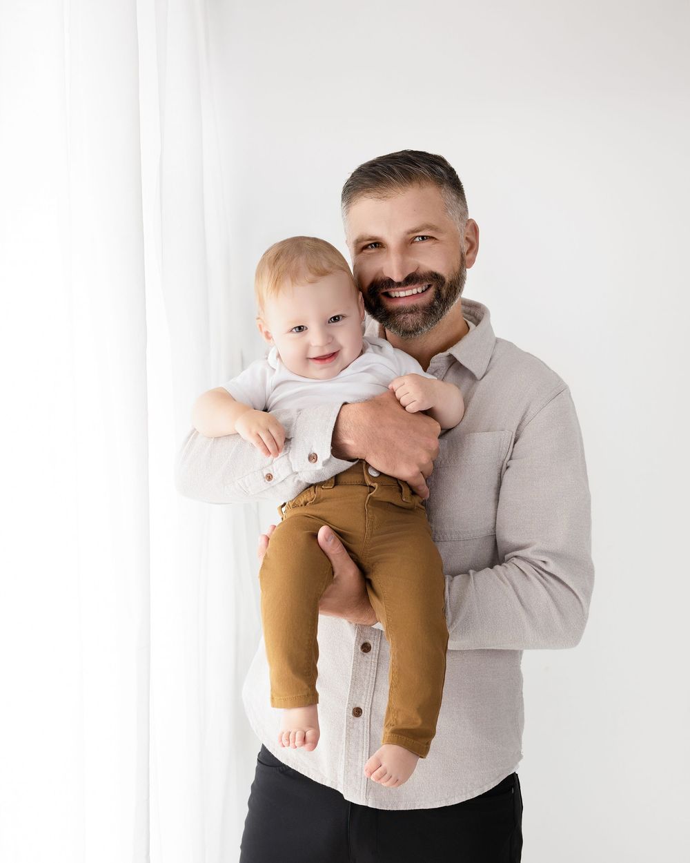 Sweet family portrait series showing playful moments in white studio setting.