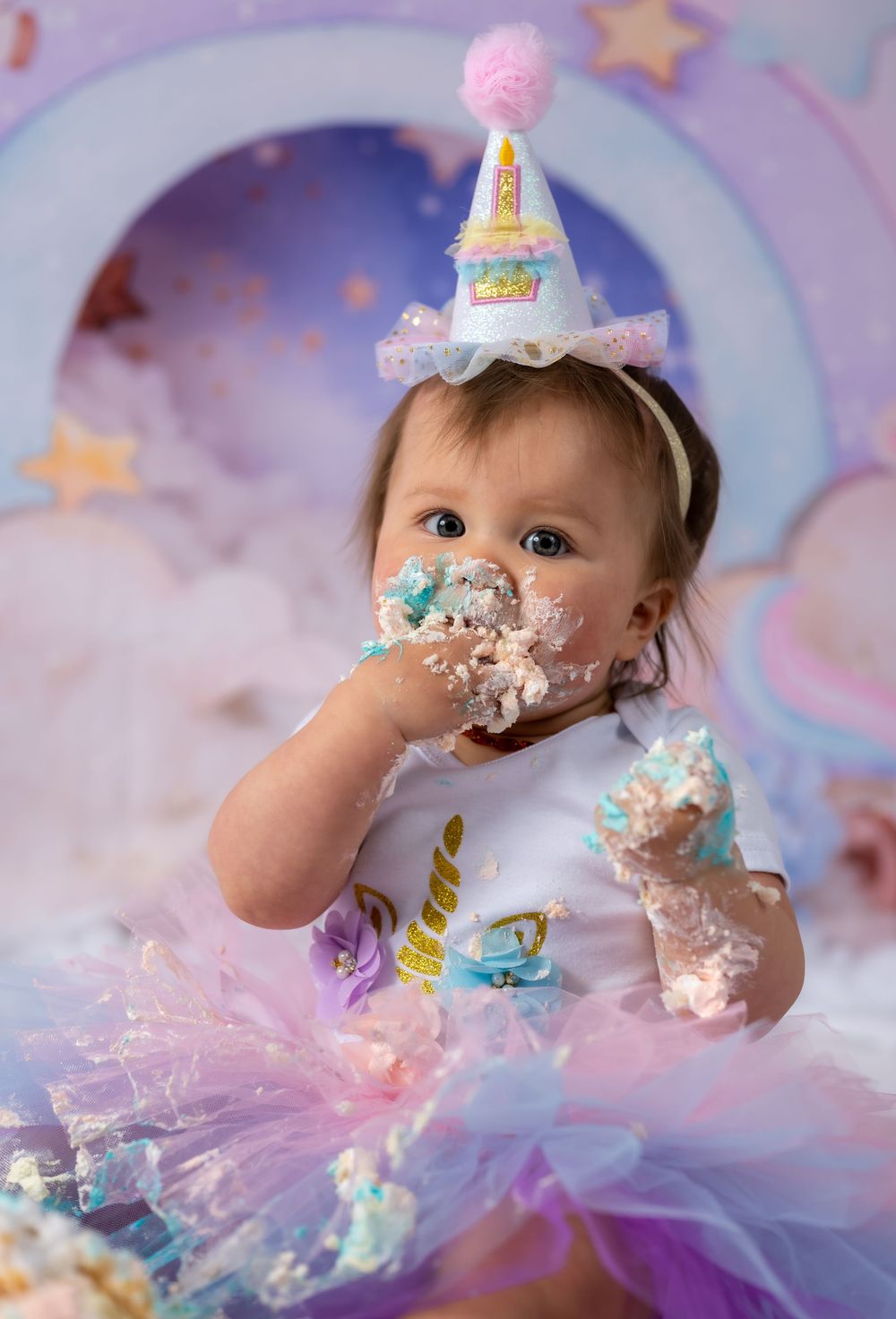 First birthday cake smash photography with pastel decorations and stars.