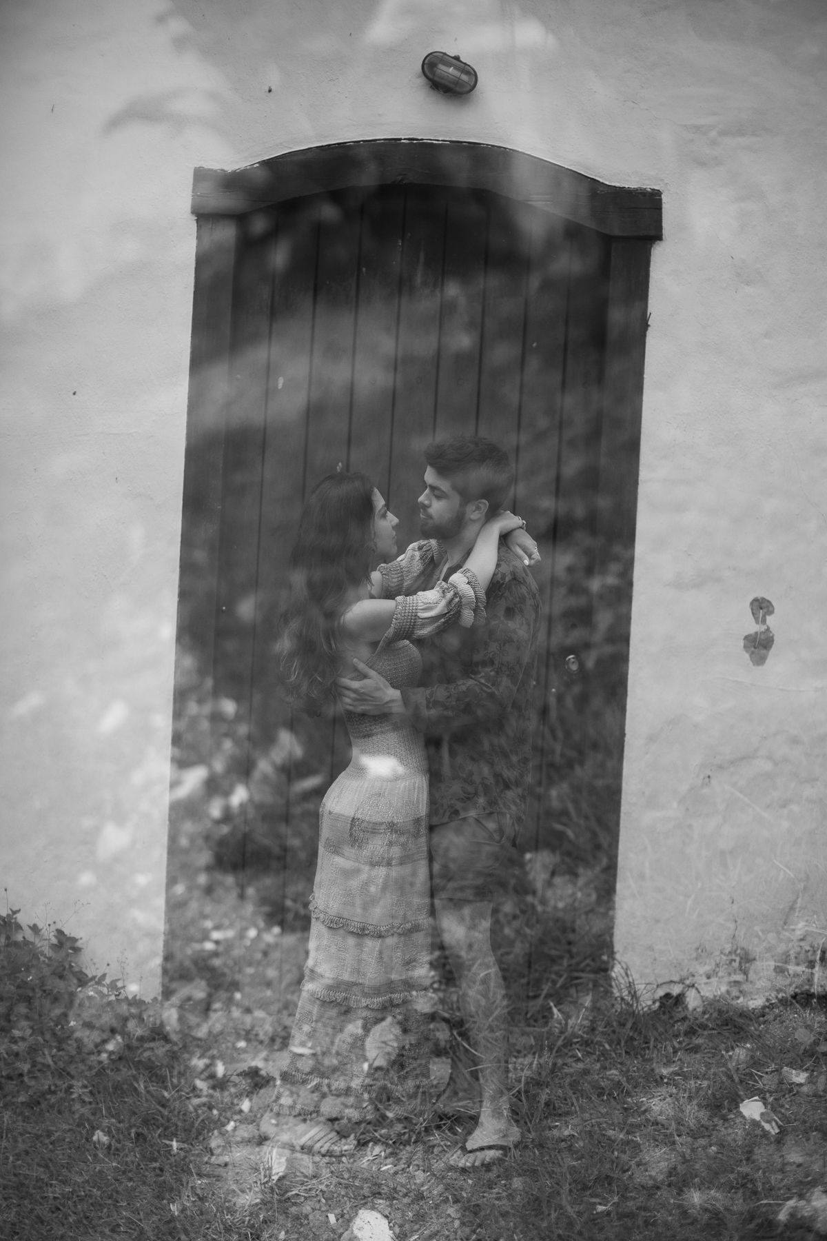 A series of vintage black and white photographs showing people in period clothing standing against a wall outdoors.