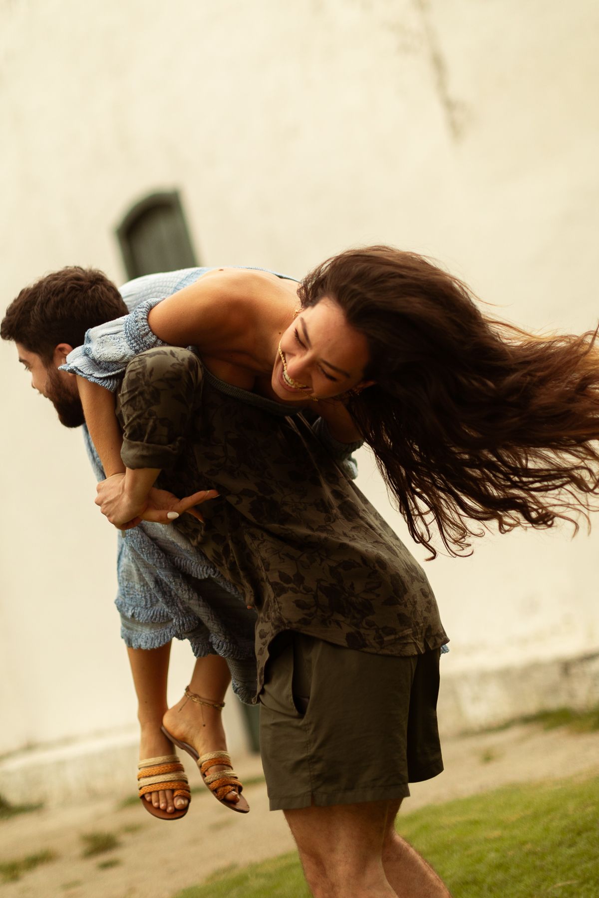 A sequence of photos showing a person with long hair spinning and twirling outdoors in casual summer clothing.