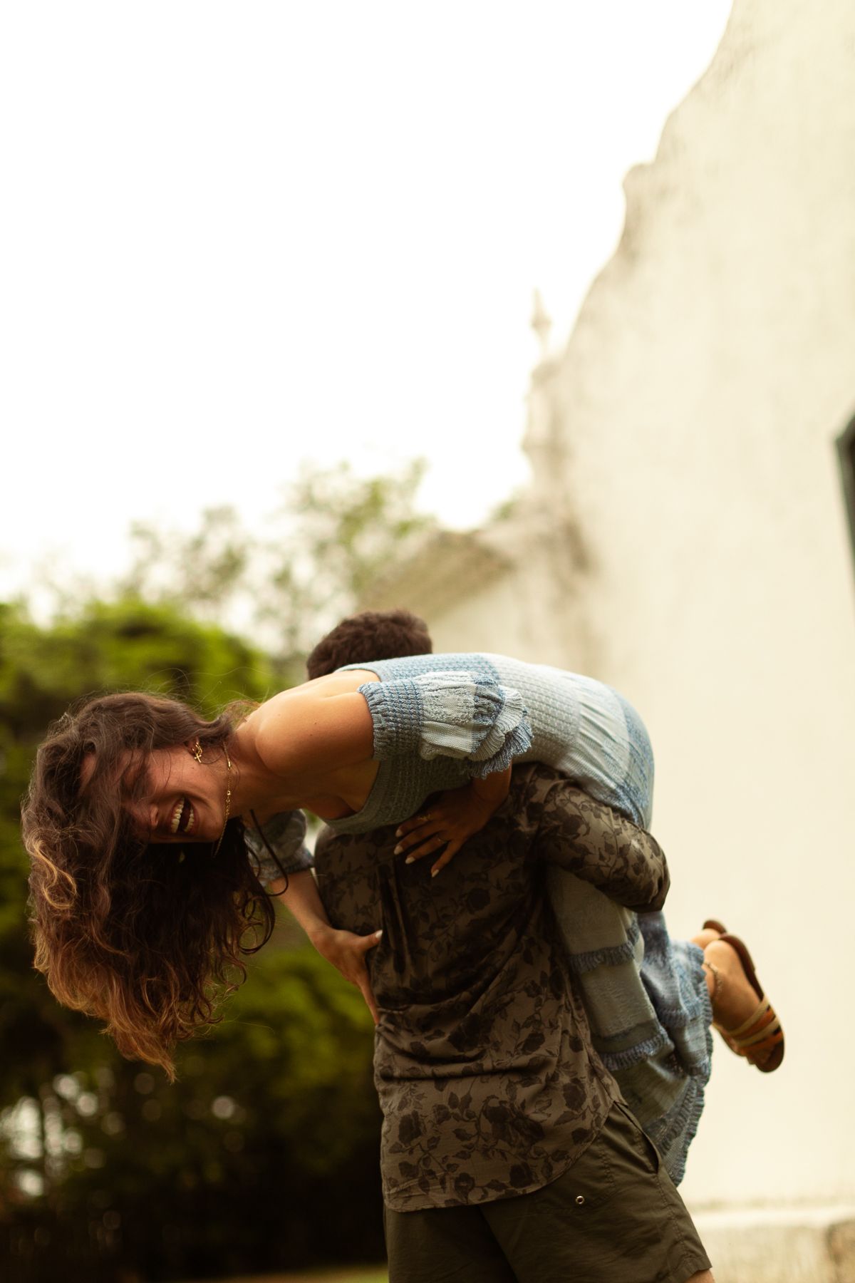 A person in a denim shirt leans backwards in a dynamic motion sequence against a light-colored background.