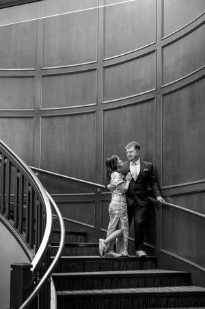 A series of black and white photos showing a romantic scene on elegant wooden stairs with curved railings.