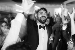 Black and white wedding reception photos showing guests dancing and celebrating on the dance floor.