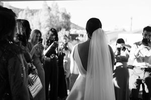 Black and white wedding photos show intimate moments during a ceremony and reception with guests and celebrations.