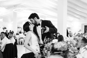Black and white photo of wedding guests dancing and celebrating at a lively reception.
