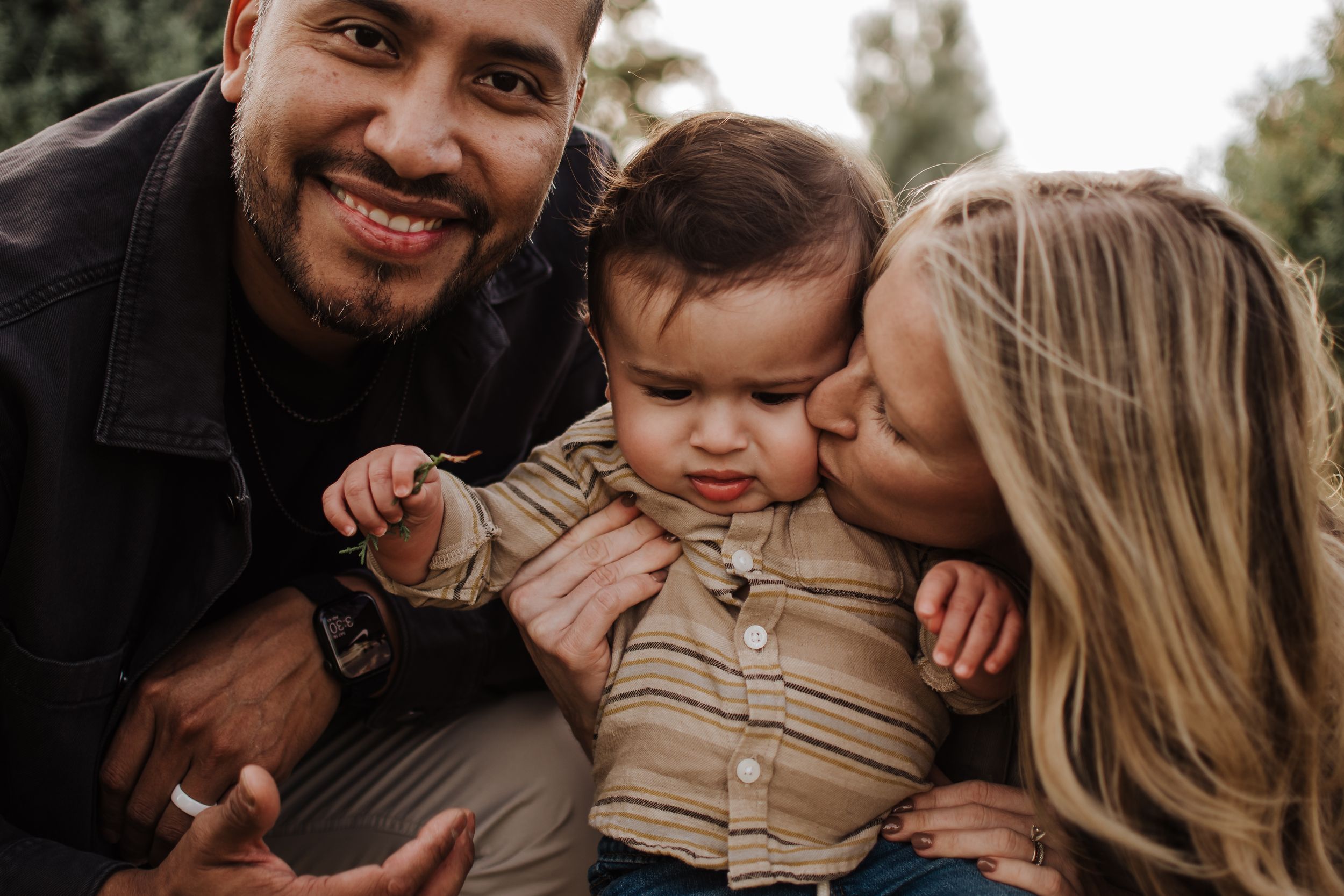 Close-up family portrait showing joyful expressions and loving interaction with their baby. Haynie Green Acres Farm