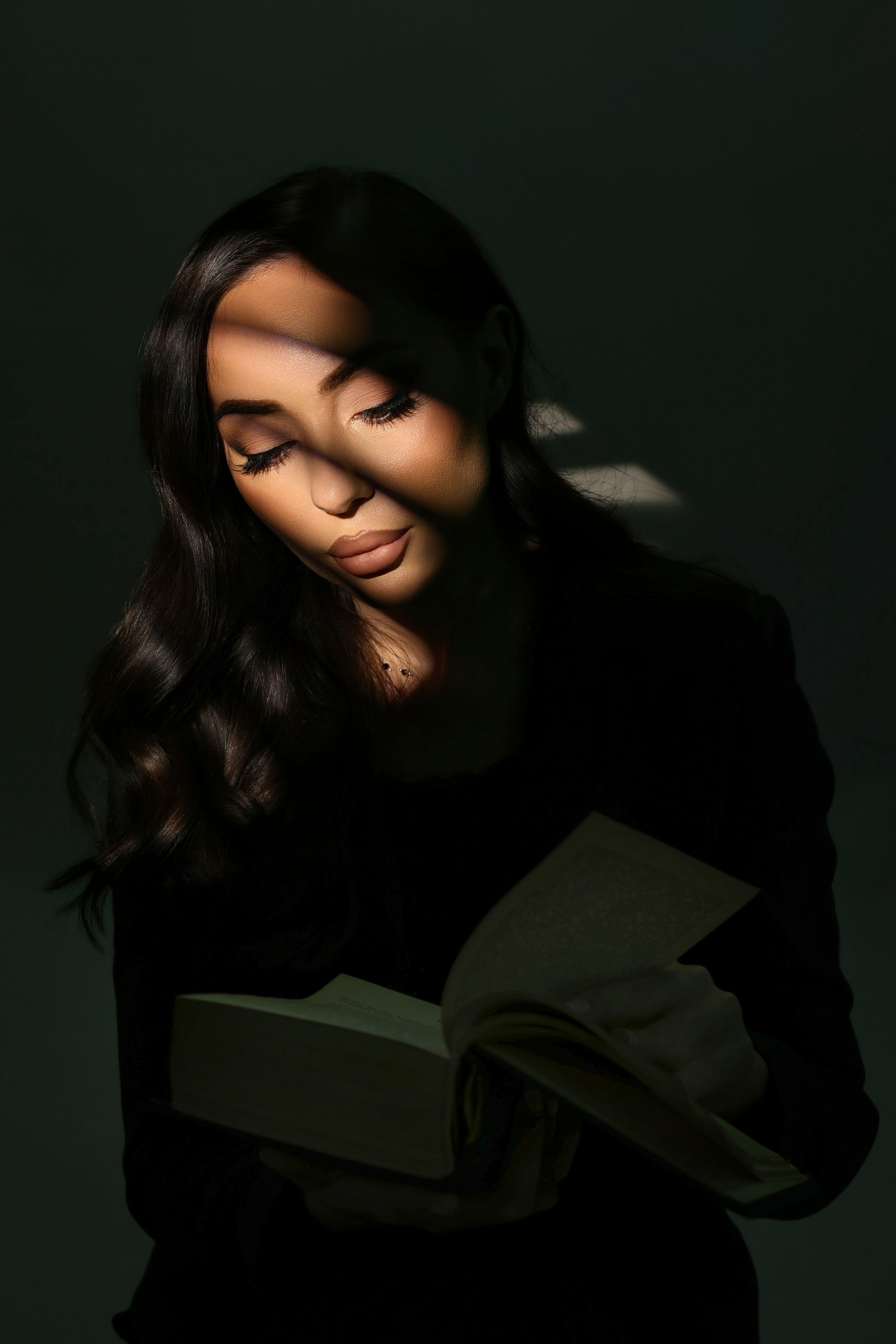 A dramatic fashion portrait series showing flowing dark hair movement against a moody black background.