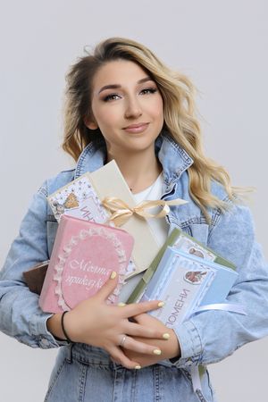 Commercial photography featuring model with pastel gift boxes in denim jacket.