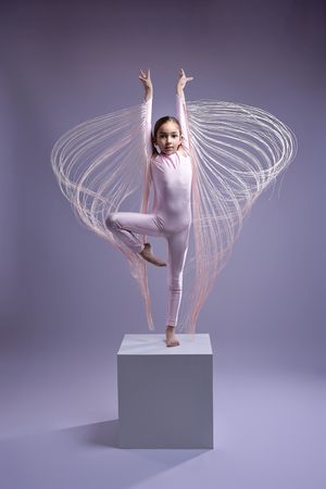 Modern dance performance on white platform with flowing motion trails captured in white costume.