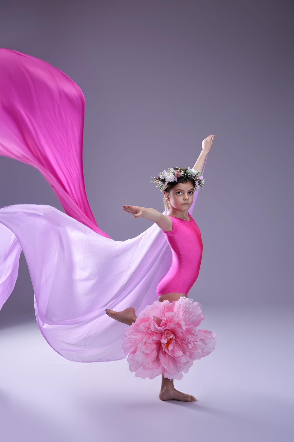 Dance performance with flowing pink fabric and floral tutu creating ethereal movement.