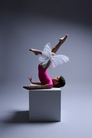 Contemporary dance sequence on white platform showing floating movements in white and pink costume.
