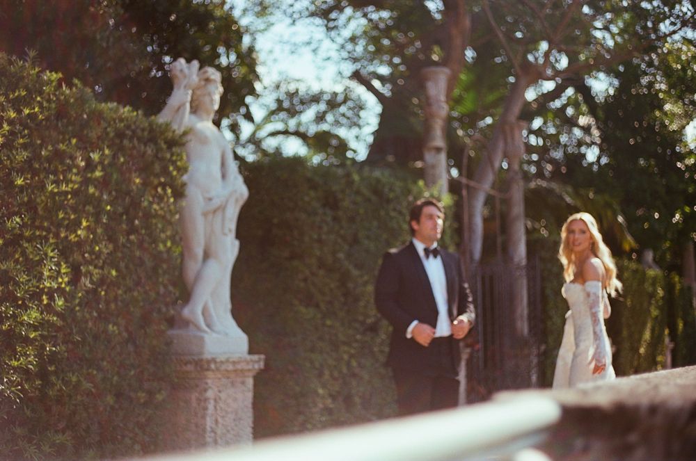 Beautiful outdoor wedding photo shoot captured in a garden setting during golden hour with ornamental statues.