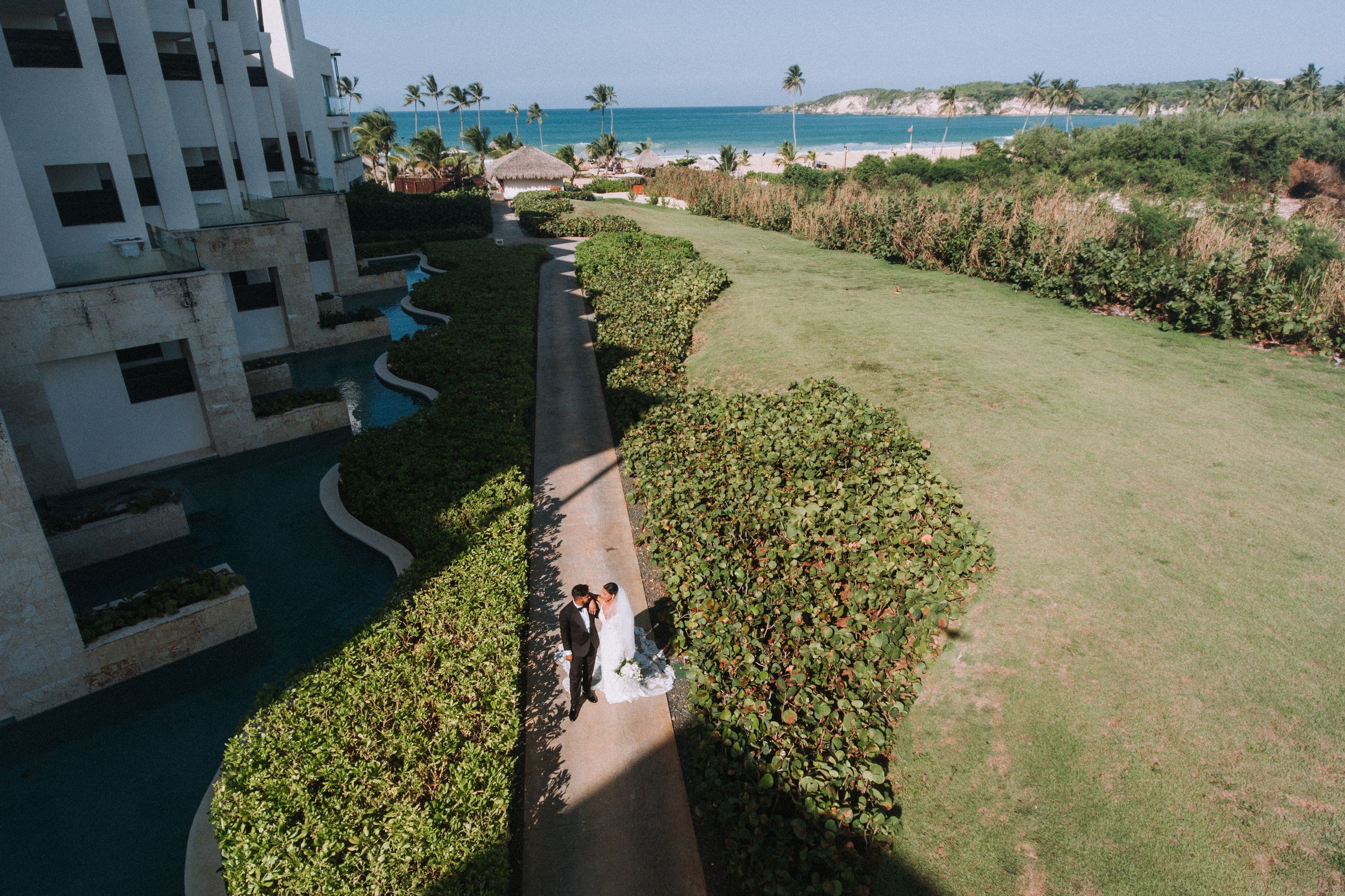 Beachfront resort property with white buildings and tropical landscaping.