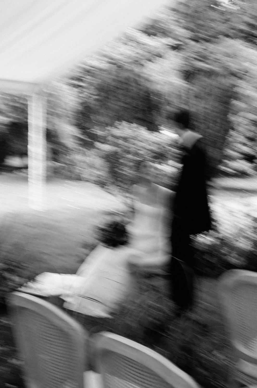 Motion blur B&W of bride & groom under ceremony tent
