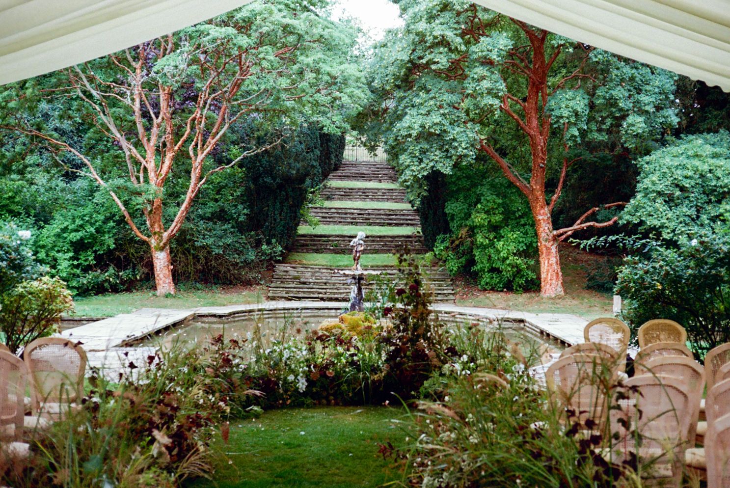 Wedding ceremony details including chairs and floral decorations underneath a tent
