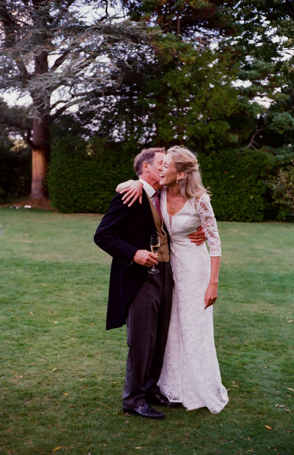 Bride embraced by elderly man. Documentary wedding