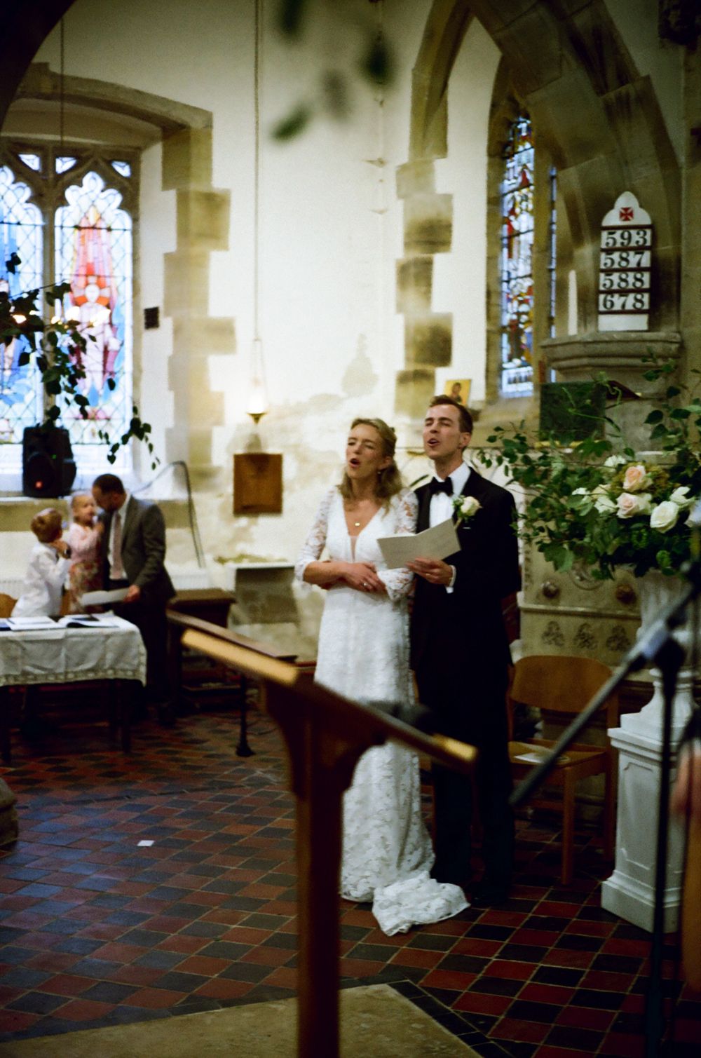 Bride & Groom in church ceremony singing from a hymn book