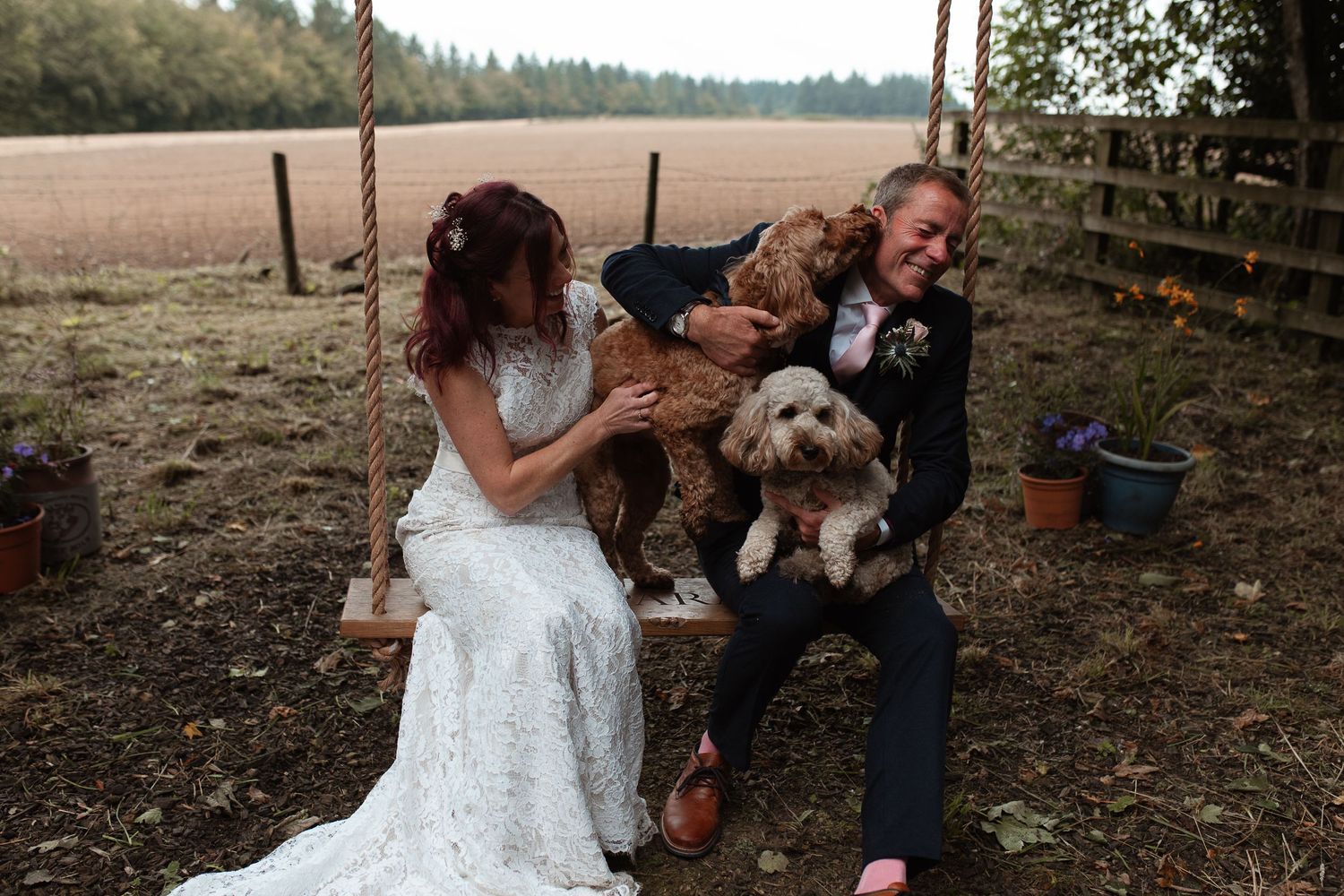 A series of six photos showing a couple holding their small white dog while celebrating their outdoor wedding.
