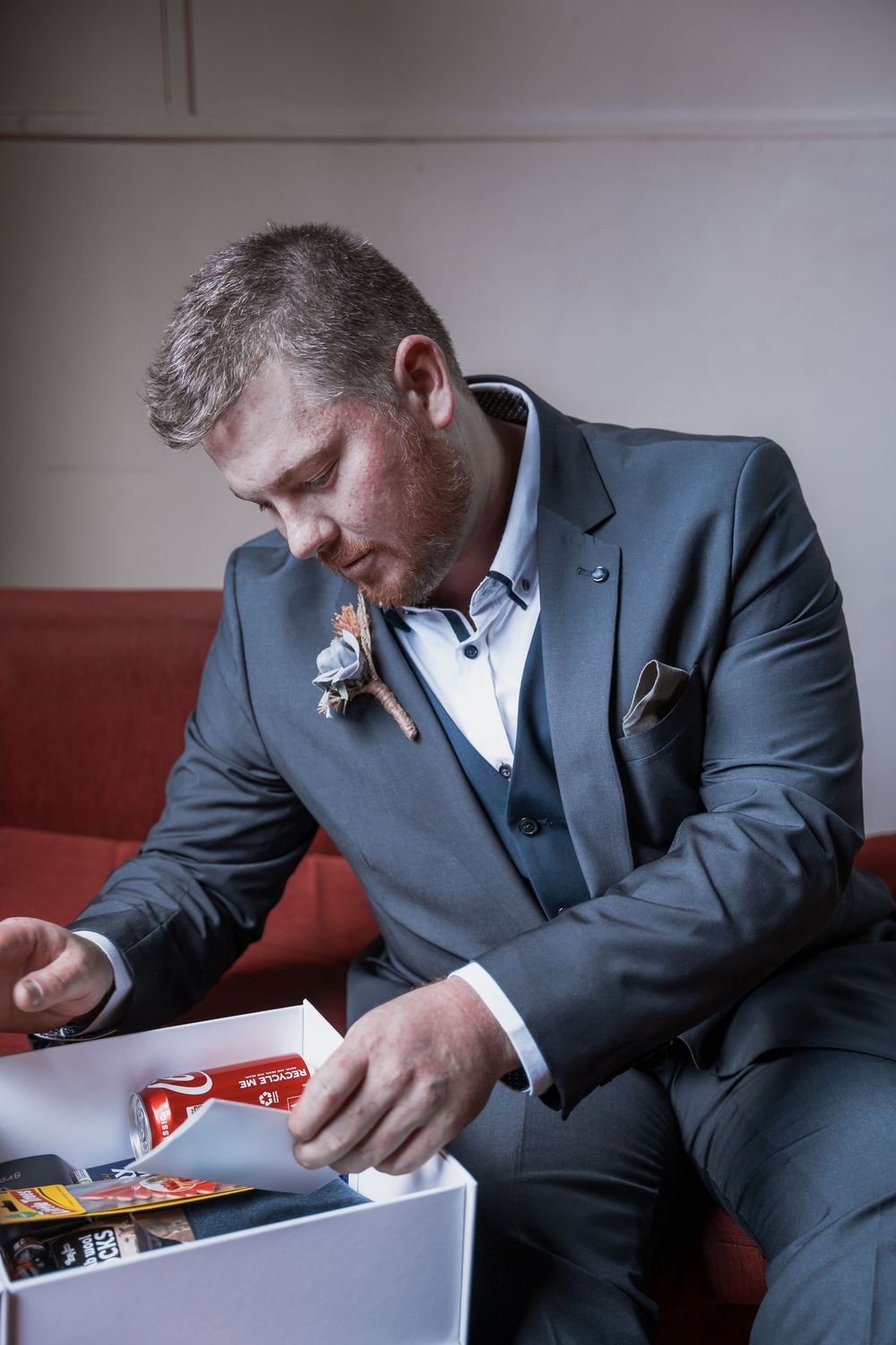 A series of images showing someone in a suit looking through a small box of items.