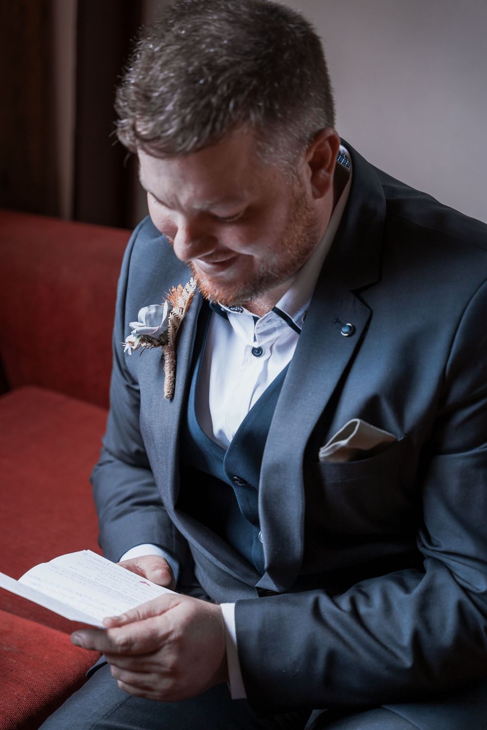 A person in a dark suit looking down at their mobile phone in a dimly lit room, shown from multiple angles.
