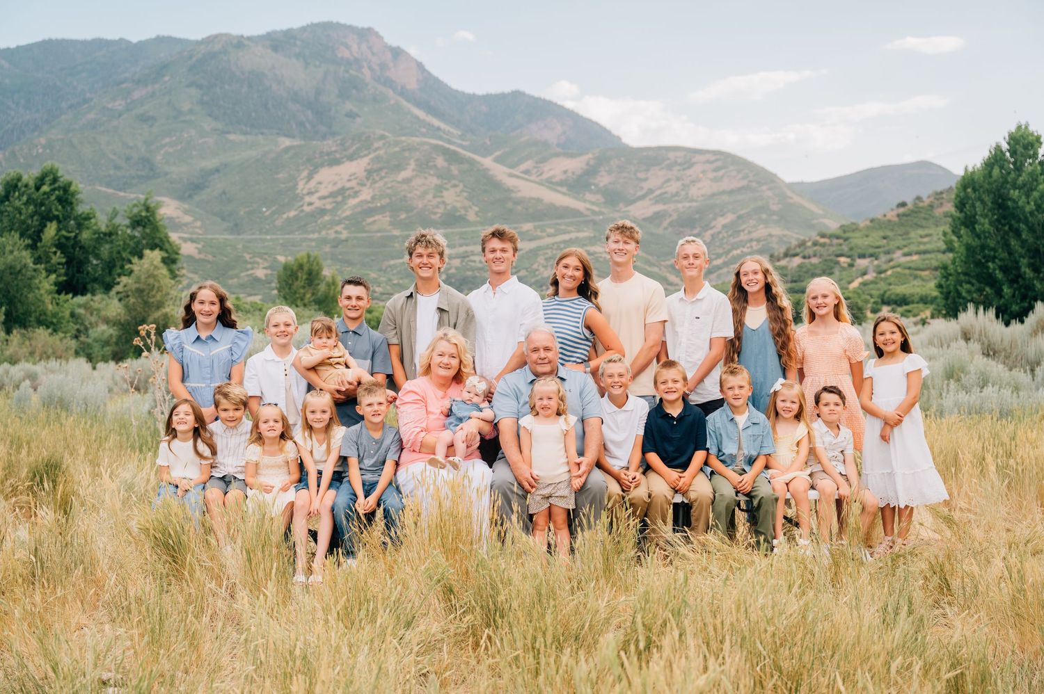 Family group photos in sequence against scenic mountain backdrop with golden grasses and natural landscape setting.