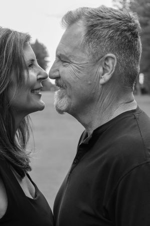 Black and white portrait of mature couple gazing lovingly at each other outdoors.