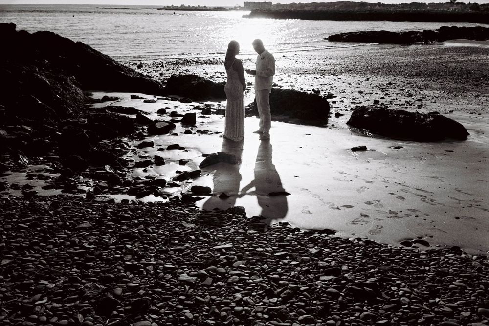 A couple read their vows privately, just the two of them at sunset on a beach in Kennebunkport.