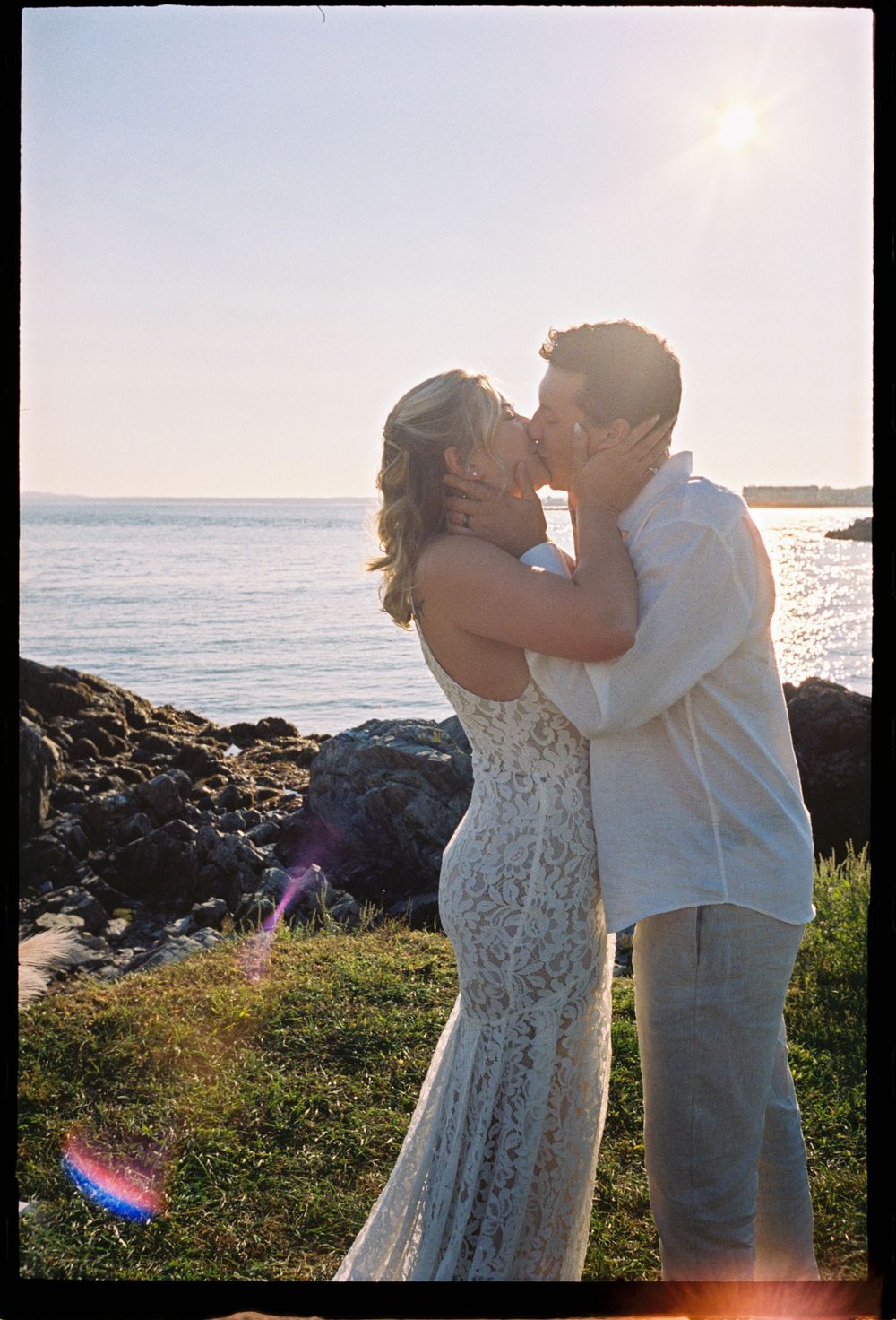 A couple kisses in the sunlight right after saying their vows in front of their family and friends on film in Kennebunk, Maine.
