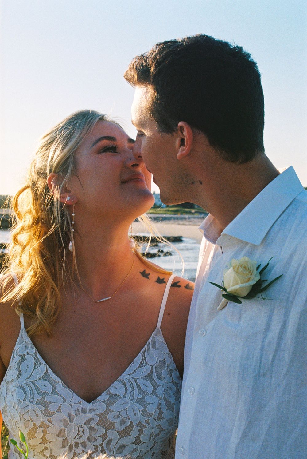 A quiet, in-between moment as a couple lean in to almost kiss each other after their intimate beach ceremony in Kennebunkport, Maine.