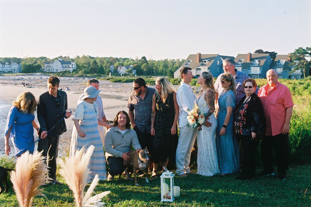 A candid photo of all the the guests laughing and smiling at each other after an intimate beach wedding on 35mm film in Kennebunkport, Maine