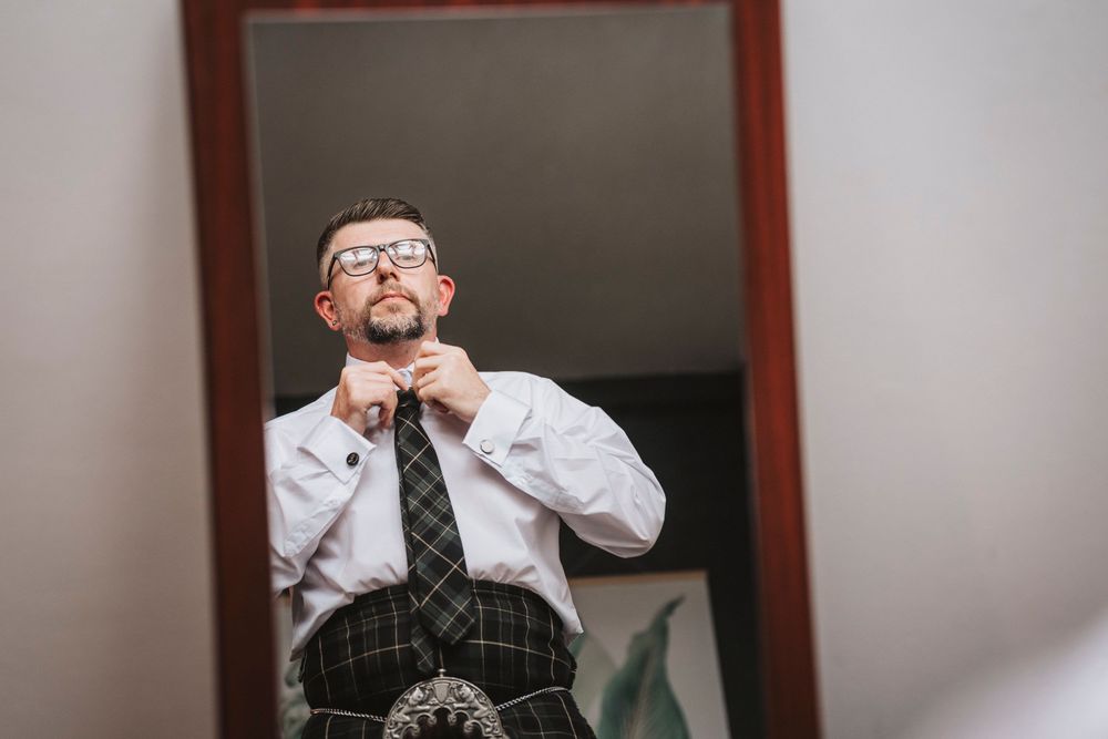 Black and white photo series showing person in business attire and glasses making expressive faces as they taste test.