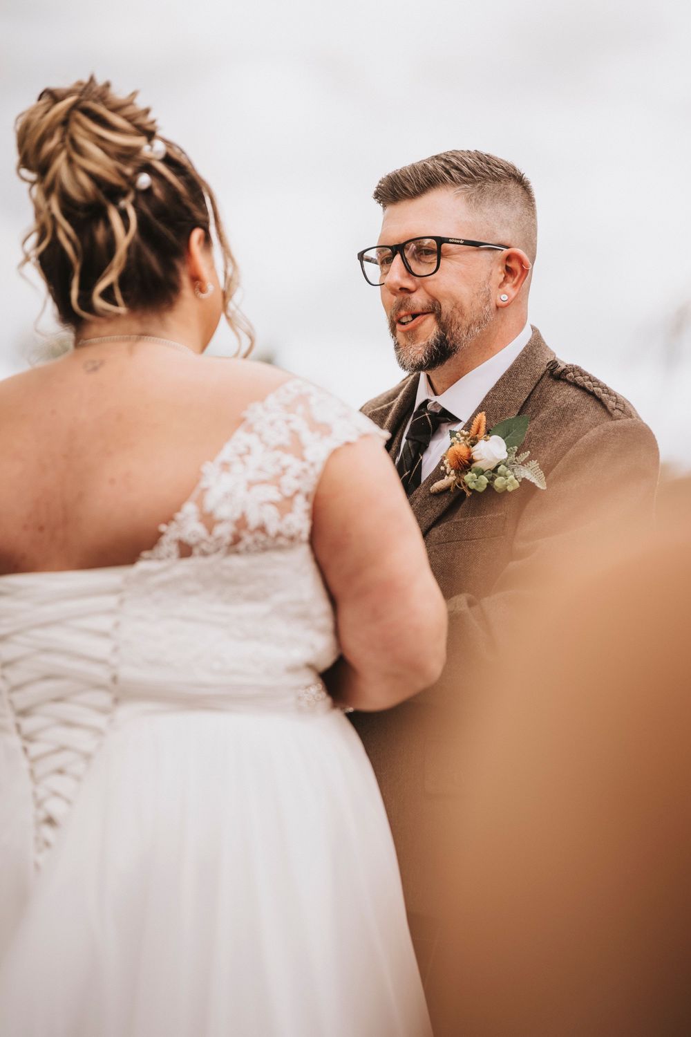 Close-up candid moments from a wedding ceremony showing the couple during their vows against a light background.