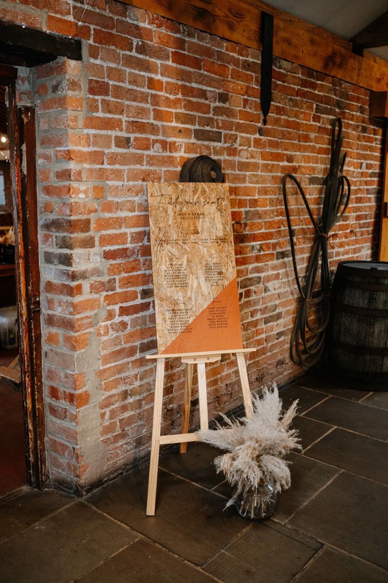 Rustic brick wall interior with dried pampas grass arrangements and wooden accents in an industrial space.