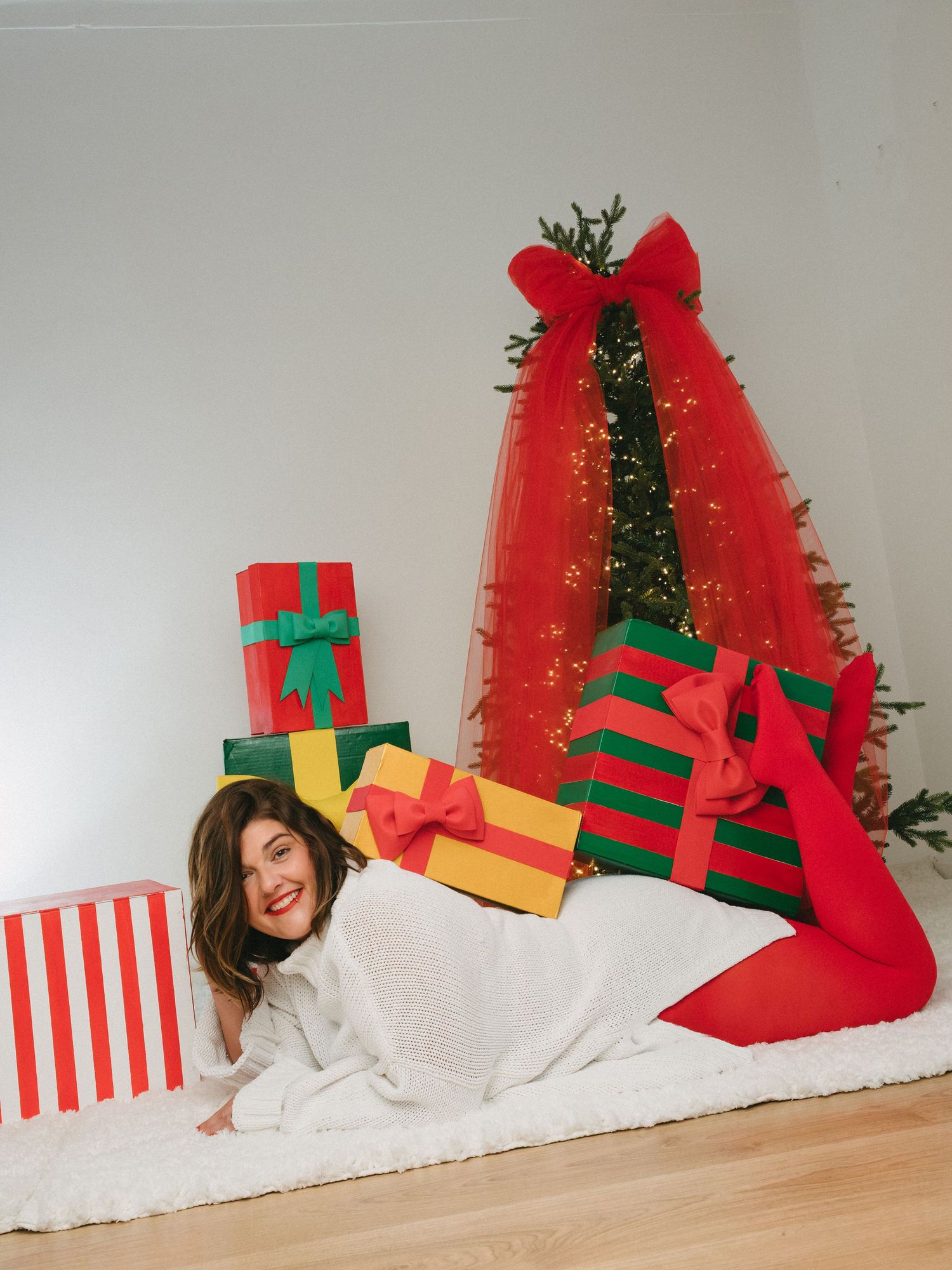 A series of festive Christmas photos showing a red sweater and large green gift boxes with yellow bows against a decorated tree.