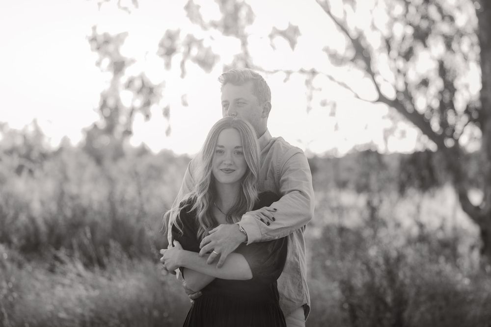 Family portrait session captured in golden sunset light among trees.