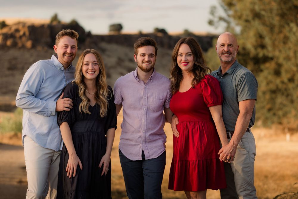 Extended family group photo taken at sunset in an outdoor natural setting.