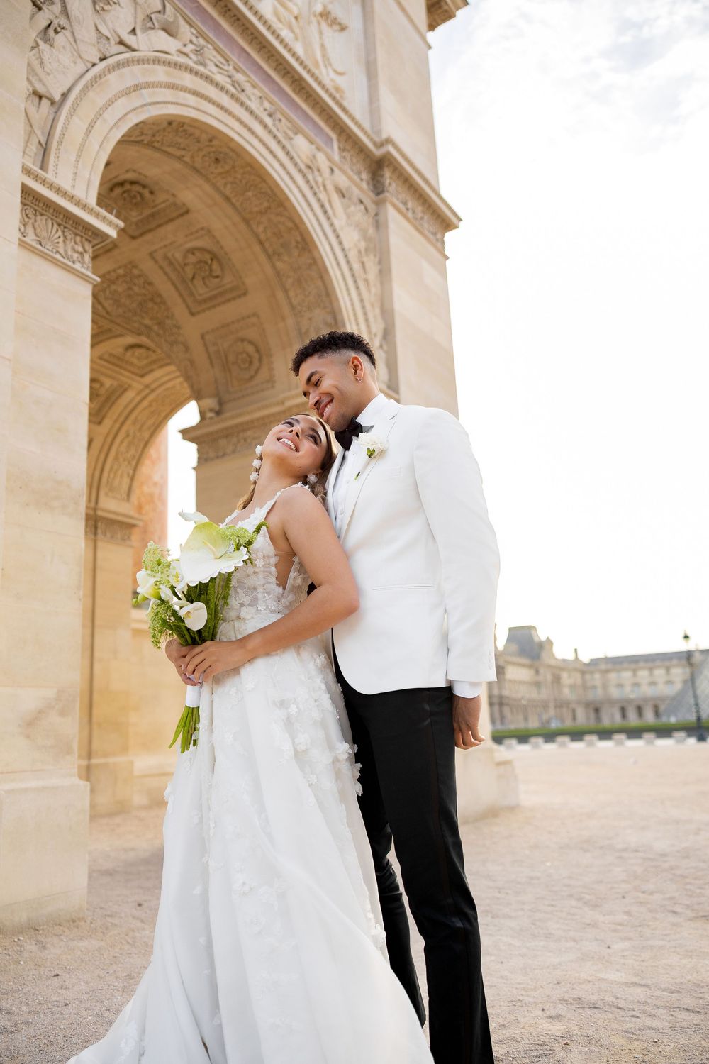 Romantic wedding portraits captured under ornate stone archways in classic architectural setting.